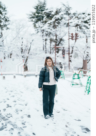 Traveler with Sweater and backpack walking on snow covered forest in frosty weather. Winter Travel, Adventure, Exploring and Vacation concept Traveler with Sweater and backpack walking on snow covered forest in frosty weather. Winter Travel, Adventure, Exploring and Vacation concept 119955822
