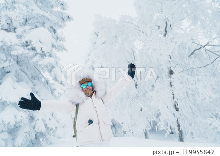 Woman tourist sightseeing Snow monster in Winter day at Mount Zao, Yamagata prefecture, Japan. Happy Traveler walking on powder snow covered in frosty weather. Travel, Adventure and Vacation Woman tourist sightseeing Snow monster in Winter day at Mount Zao, Yamagata prefecture, Japan. Happy Traveler walking on powder snow covered in frosty weather. Travel, Adventure and Vacation 119955847
