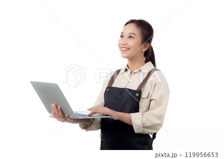 Portrait young asian business woman wearing apron holding laptop computer isolated. Portrait young asian business woman wearing apron holding laptop computer isolated. 119956653