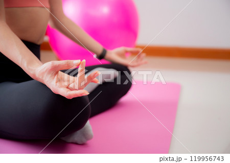 Young asian woman meditation sitting on mat in serene and tranquility with yoga posture lotus. 119956743
