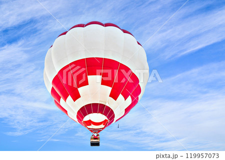 Colorful hot air balloon flying over blue sky with white clouds	 119957073