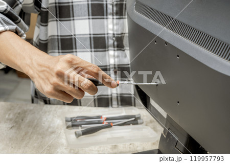 Man technician repairing television with a screwdriver Man technician repairing television with a screwdriver 119957793