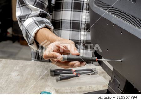 Man technician repairing television with a screwdriver 119957794
