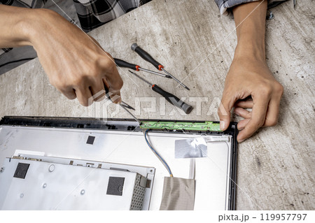 Man technician repairing television with a screwdriver Man technician repairing television with a screwdriver 119957797