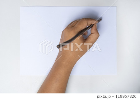 Human hand writing using calligraphy reeds on white paper Human hand writing using calligraphy reeds on white paper 119957820