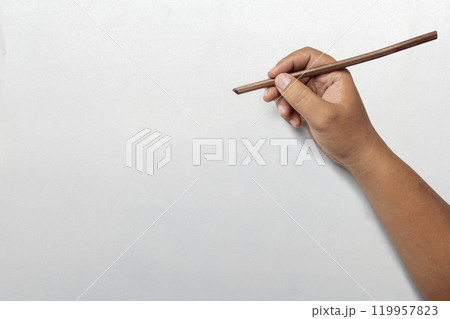 Human hand writing using calligraphy reeds on white paper Human hand writing using calligraphy reeds on white paper 119957823