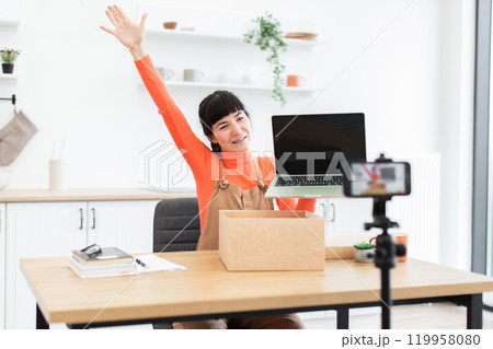 Caucasian female unboxing new laptop during online video recording 119958080
