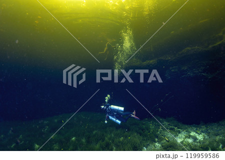 Diving in Mexican Cenote underwater cave with green gas cloud Diving in Mexican Cenote underwater cave with green gas cloud 119959586