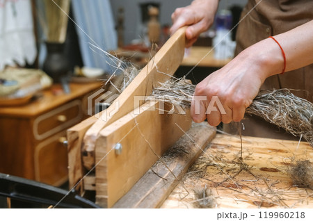 Traditional craftsmanship: fiber processing by hand for artisanal textile production 119960218
