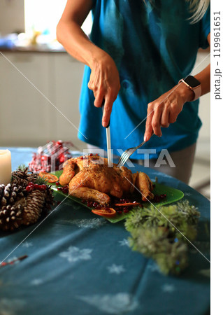 carving a beautifully roasted turkey, a centerpiece of the Christmas feast. This moment reflects the cherished traditions of holiday cooking and the warmth of family celebrations 119961651