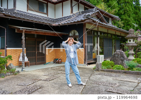 古民家の前で頭を抱える女性 空き家 田舎 相続 古民家の前で頭を抱える女性 空き家 田舎 相続 119964698
