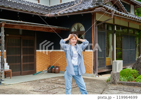 古民家の前で頭を抱える女性 空き家 田舎 相続 古民家の前で頭を抱える女性 空き家 田舎 相続 119964699