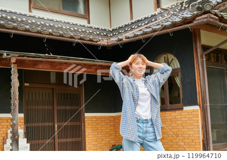 古民家の前で頭を抱える女性　空き家　田舎　相続 119964710