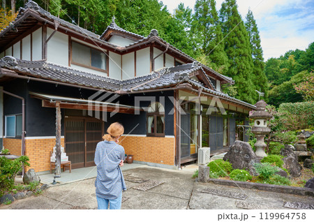 古民家の前で首をかしげる女性　空き家　相続　田舎 119964758