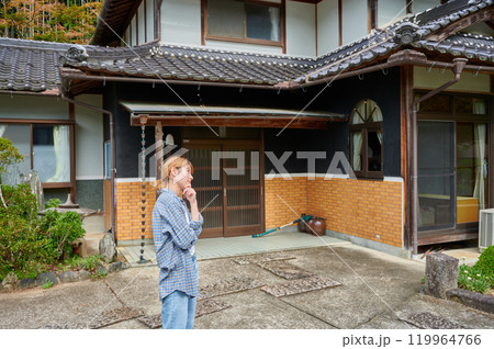古民家の前で首をかしげる女性 空き家 相続 田舎 古民家の前で首をかしげる女性 空き家 相続 田舎 119964766