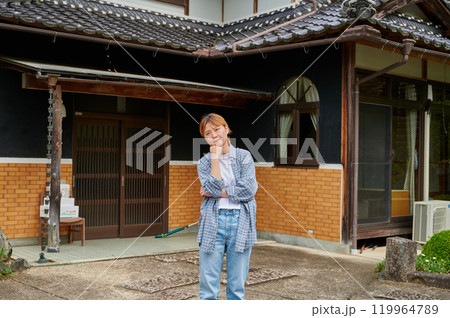 古民家の前で首をかしげる女性　空き家　相続　田舎 119964789
