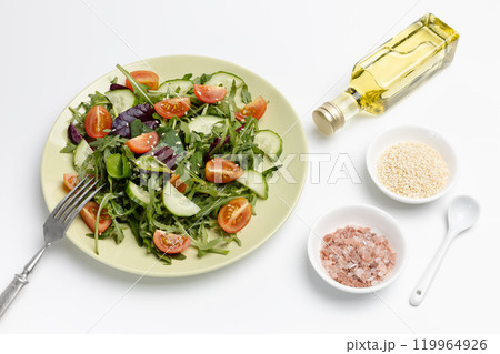 Vegetable salad of tomato, cucumber, greens on the plate with a fork. 119964926