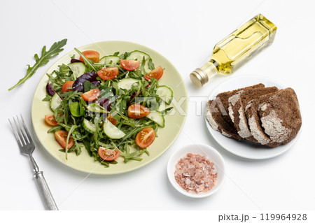 Vegetable salad of tomato, cucumber, greens on the plate with olive oil. 119964928