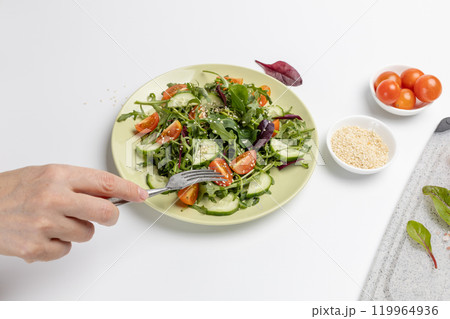 Vegetable salad of tomato, cucumber, greens on the plate with olive oil. 119964936