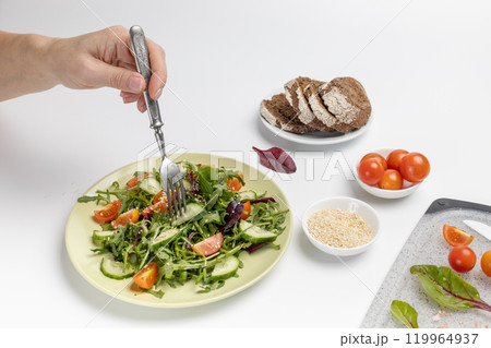 Vegetable salad of tomato, cucumber, greens on the plate with olive oil. 119964937