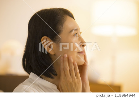 夜、スキンケアをするミドル女性　 119964944