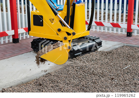 Mini excavator at the construction site. Compact construction equipment for earthworks Mini excavator at the construction site. Compact construction equipment for earthworks 119965262