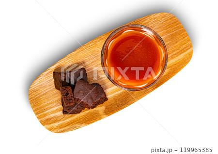 Top view pile of crispy brownie chocolate cube and a glass of tomato juice. Top view pile of crispy brownie chocolate cube and a glass of tomato juice. 119965385