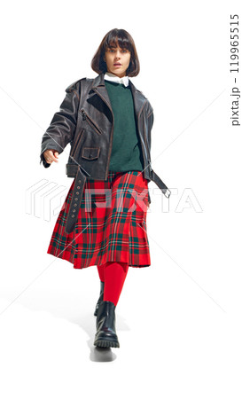 Young woman in leather jacket paired with green sweater and plaid skirt, exuding rebellious yet classic fashion sense against white studio background. 119965515