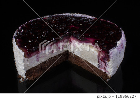 Piece of cake with coconut shavings and currant in jelly on a black background Piece of cake with coconut shavings and currant in jelly on a black background 119966227