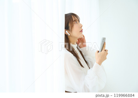 イヤホンをする若い女性　 119966884