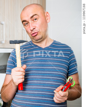 Man posing with hammer in his hands Man posing with hammer in his hands 119967188
