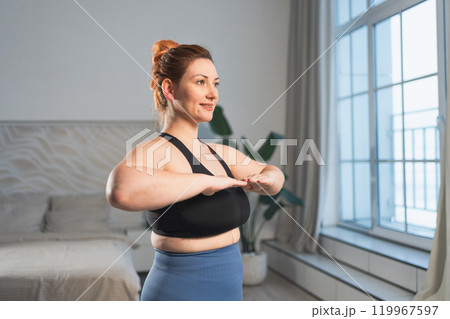 Fitness workout training. Woman practicing fitness at home. Plus size female doing sports exercise at home indoor. Girl in sportswear have workout weight training for weight loss. Sport and fitness 119967597