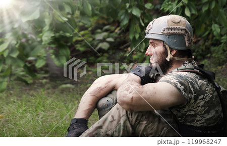 Lone sad soldier sitting in the forest Lone sad soldier sitting in the forest 119968247