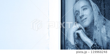 Young girl at the window Young girl at the window 119968248