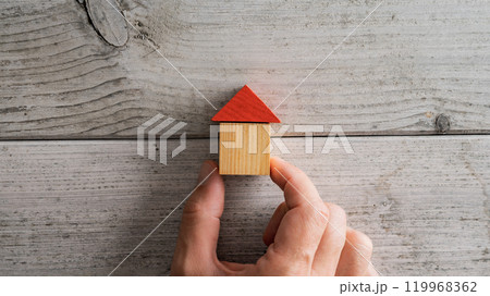 House made of wooden blocks over a textured white wooden background 119968362