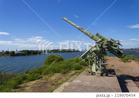Cannons on island Lansi Mustasaari, Suomenlinna sea fortress with Helsinki city center in background, sunny summer day Cannons on island Lansi Mustasaari, Suomenlinna sea fortress with Helsinki city center in background, sunny summer day 119970454