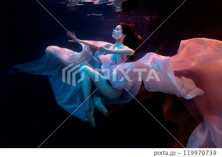 Attractive woman, model, ballerina underwater in a fluttering dress. Soft blurred focus. 119970739