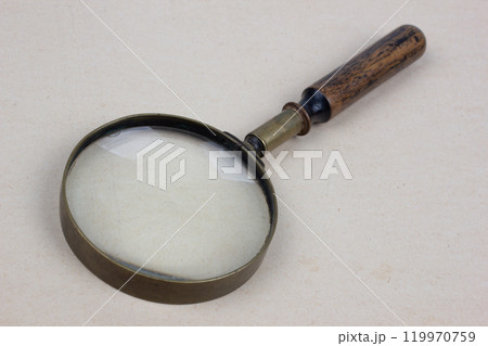 Antique magnifying glass on paper 119970759