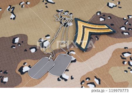 US ARMY Sergeant rank patch and dog tags on desert camouflage uniform background 119970773
