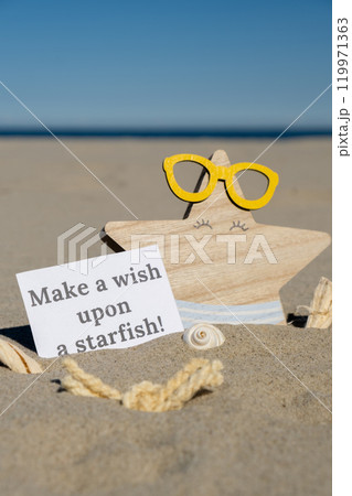 MAKE A WISH UPON A STARFISH text on paper greeting card on background of funny starfish in glasses summer vacation decor. Sandy beach sun coast. Holiday concept postcard. Getting away Travel MAKE A WISH UPON A STARFISH text on paper greeting card on background of funny starfish in glasses summer vacation decor. Sandy beach sun coast. Holiday concept postcard. Getting away Travel 119971363