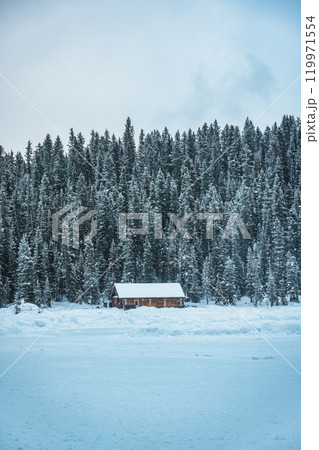 Scenery of Lake Louise with wooden cottage glowing and rocky mountains with snow covered in winter at Banff national park 119971554