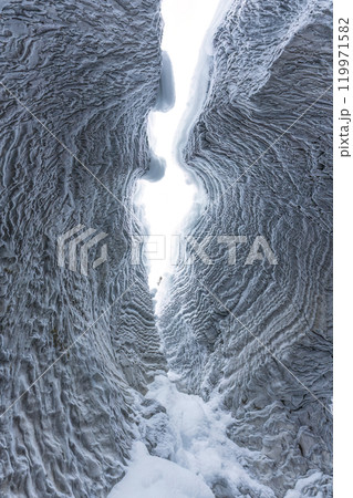 Ice cave with rock formation of water eroded on winter 119971582