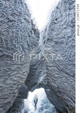 Ice cave with rock formation of water eroded on winter Ice cave with rock formation of water eroded on winter 119971594