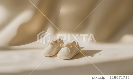 Minimalist baby shoes with neutral background for nursery decor or baby announcement 119971733