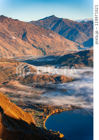 Landscape of sunlight over mountain and foggy on the lake in autumn at Roys Peak, New Zealand Landscape of sunlight over mountain and foggy on the lake in autumn at Roys Peak, New Zealand 119971821