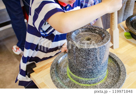抹茶の石臼を挽く子供（7歳児／男の子） 119971848