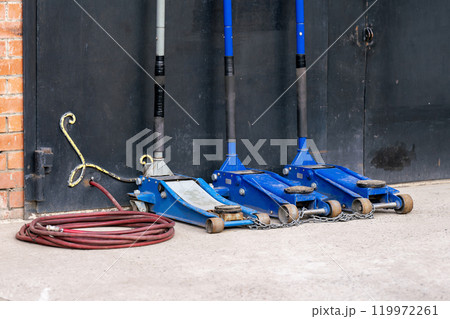 Three car jacks at the garage door. 119972261