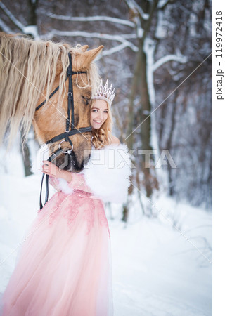 Princess in crown with horse in winter. Fairy tale, snowy queen 119972418