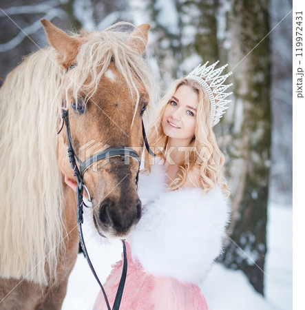 Princess in crown with horse in winter. Fairy tale, snowy queen 119972431