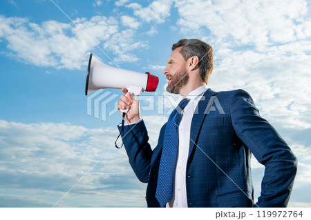 businessman shout in loudspeaker on sky background businessman shout in loudspeaker on sky background 119972764